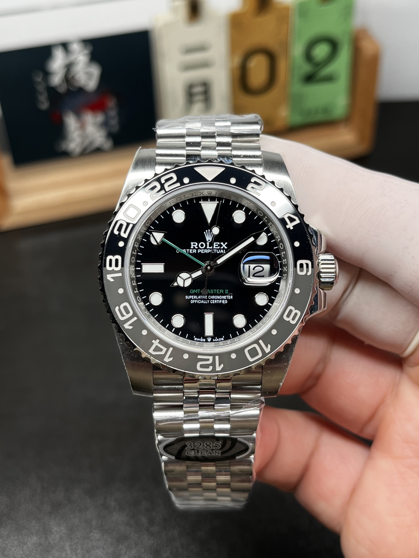 Black dial Rolex GMT-style replica watch with stainless steel bracelet and ceramic bezel